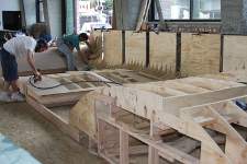 A cold molded deck was built from 1/8 inch thick strakes of bendable wood. Shown is the first of five layers being installed