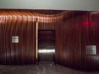 Vertical fins of solid bent hardwood are placed on top of a cold molded walnut base to create a highly textured visual image